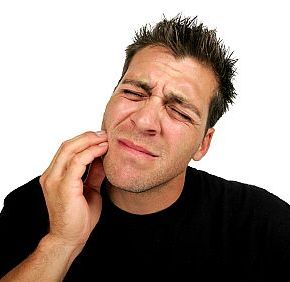 Man grabbing his tooth in pain.