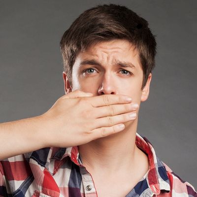 Brunette teenage boy covering his mouth, portraying a knocked-out tooth emergency